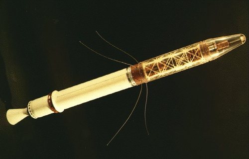 An image of the first US satellite, Explorer 1, a long and thin cylindrical spaceship with some thin cables extending out of the side as antennae.