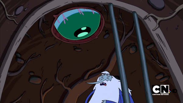A giant eye looms above the ice king in his cell.