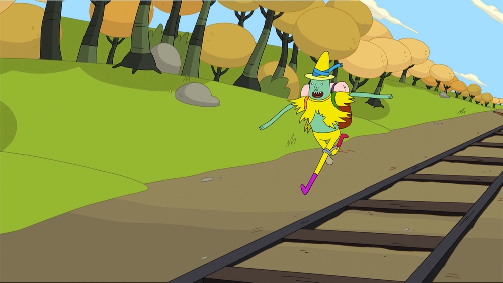 Still from the scene of Magic Man fleeing Grob God Glob Grod through a forest besides a railway line.