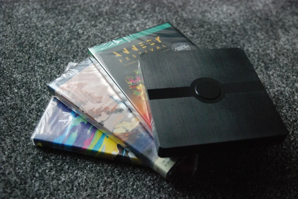 A photo of three DVD cases with a small black player box on top.