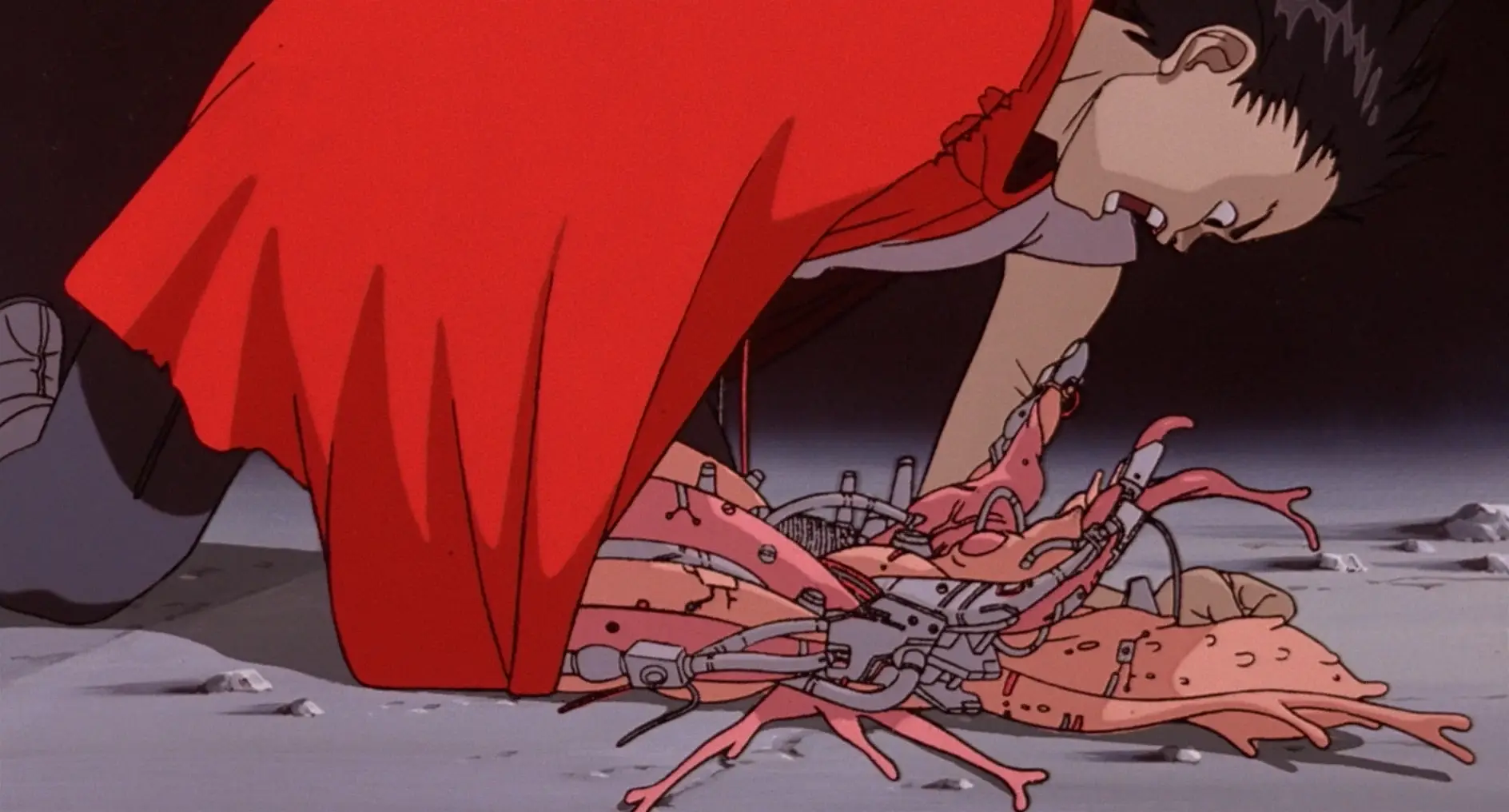 Still from Akira. Tetsuo has collapsed on the floor and his robot arm has turned into a mass of flesh mixed in with robotic elements.