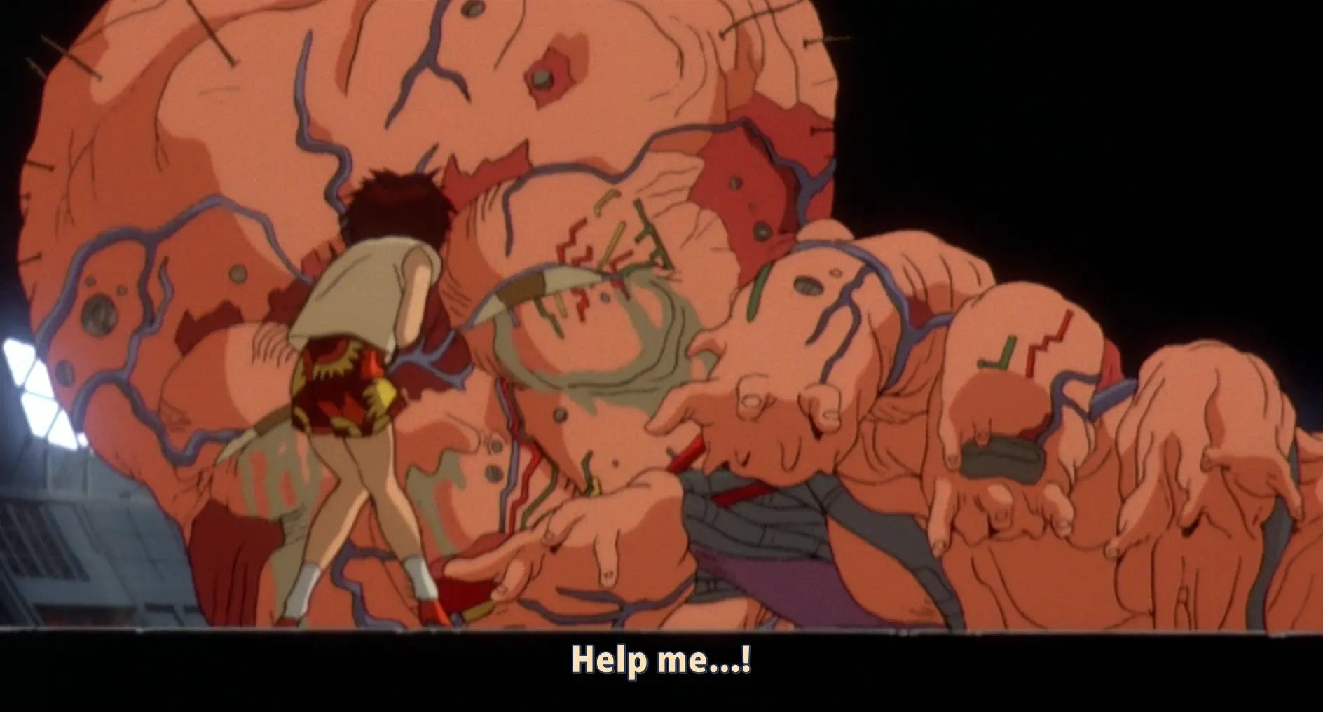 Still from Akira. Tetsuo is now a huge mass of flesh, grasping with a huge hand. Tiny fingers poke out the ends of his larger fingers. Knots of wires can be seen here and there within the flesh. He begs for help. In the foreground, Kaori stands frozen in fear, about to be engulfed.