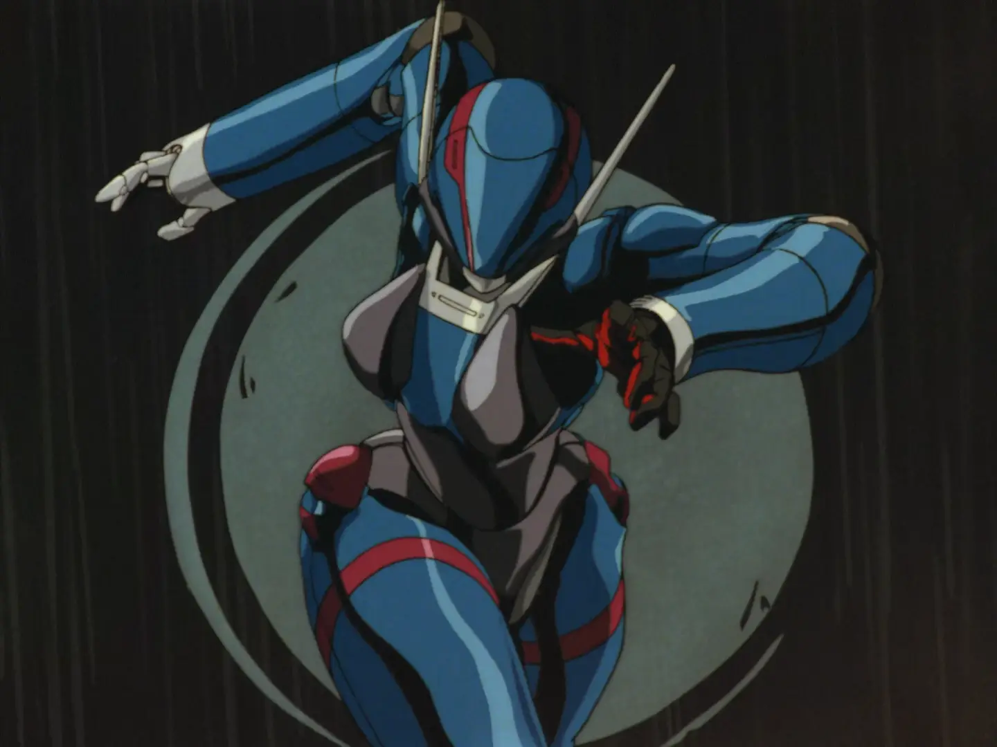 Still from Bubblegum Crisis showing one of the Knight Sabers running forwards in her suit. The suit is blue with red and white accents; it has molded structures over the breasts. The helmet fully covers the face and slightly resembles a motorbike helmet.
