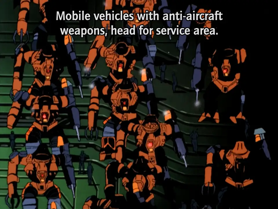 Still from Dallos in which a group of bright orange humanoid mechs advance in ranks. Each one has a large spike driver on its left arm and a claw on its right. Humans, coming up to the robots' knees, stand around nearby.