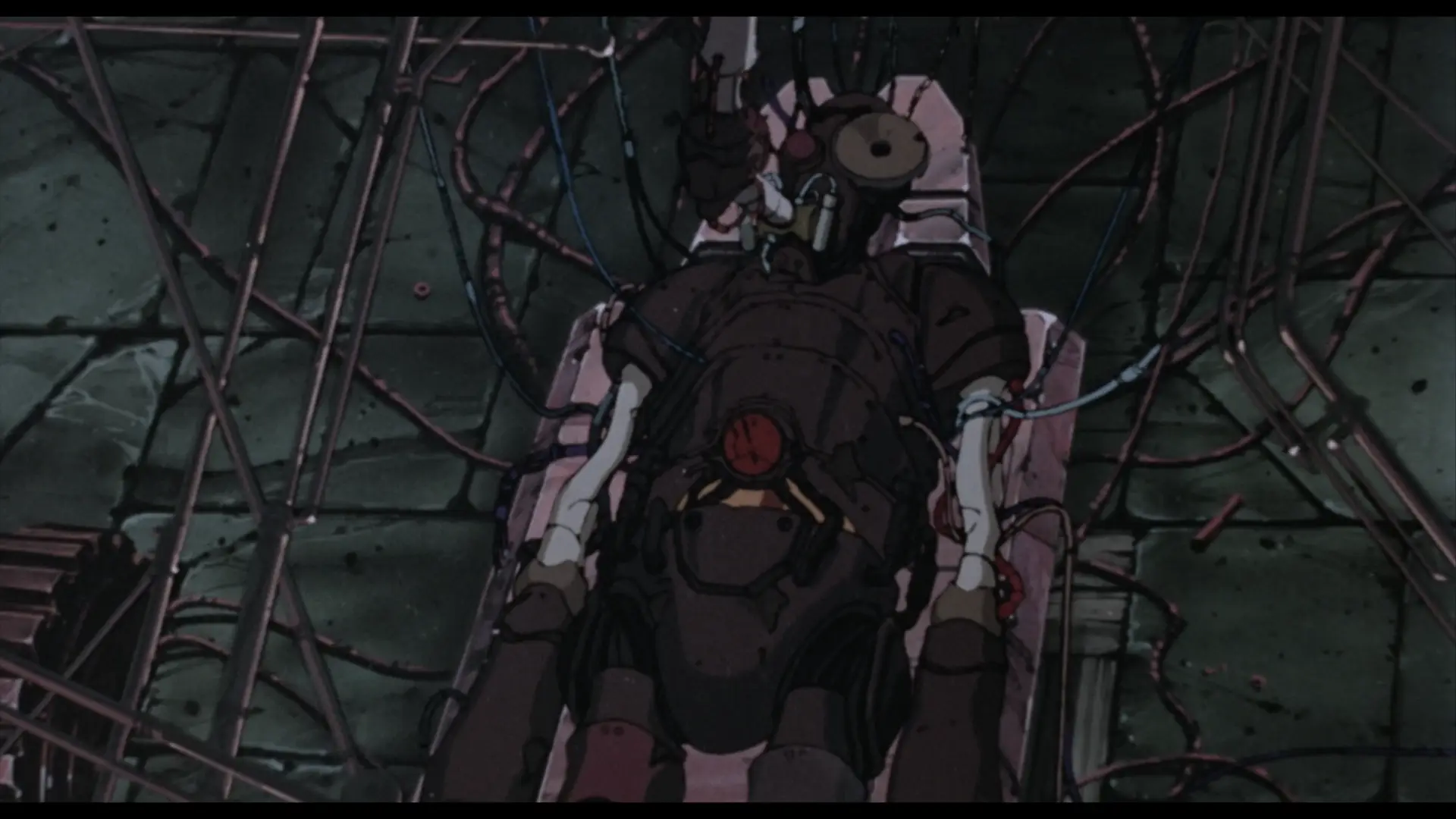 Still from Franken's Gears. The robot lies on its back, surrounded by pipes and wires, some of which connect to the robot itself and others running along the floor. Its shell is mostly brown metal, but its arms are white, with a split pattern resembling bone.