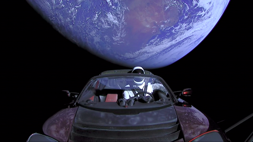 Image of a car in space, launched as part of a publicity stunt earlier this year. The car, with a dummy astronaut sitting at the wheel, sits in the foreground, while the Earth hangs in the background.