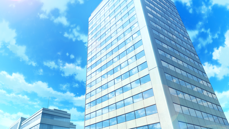 A tall rectangular building against a blue, slightly cloudy sky.